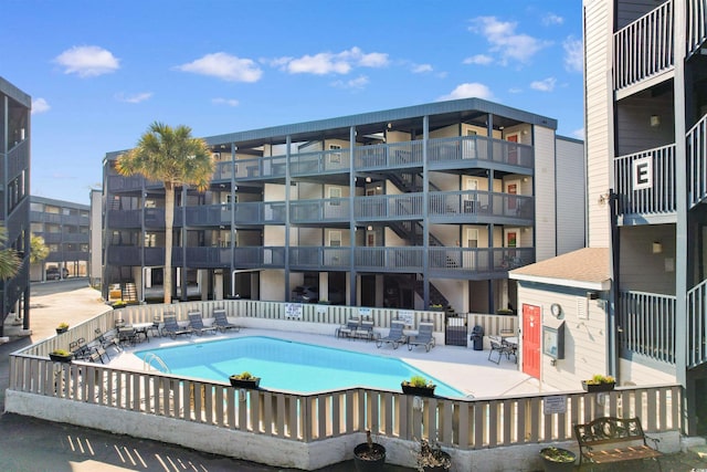 community pool with a patio and fence