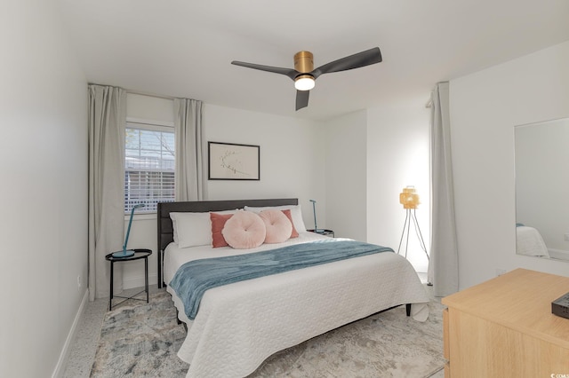 bedroom with ceiling fan, baseboards, and carpet flooring