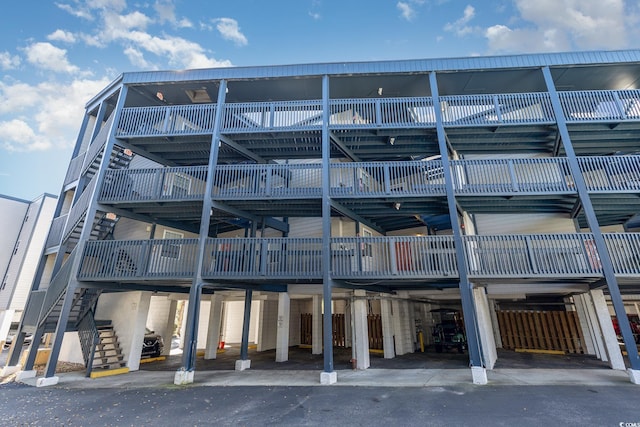 view of building exterior with a carport and stairway