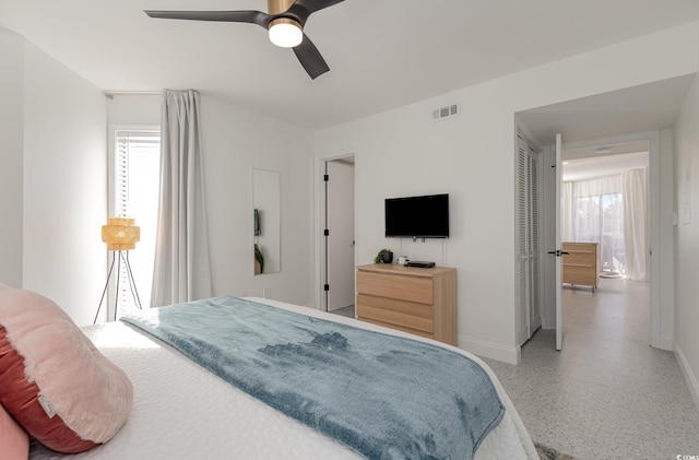 bedroom featuring baseboards, visible vents, a ceiling fan, speckled floor, and a closet