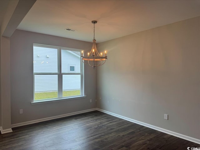 spare room with a notable chandelier, visible vents, dark wood finished floors, and baseboards