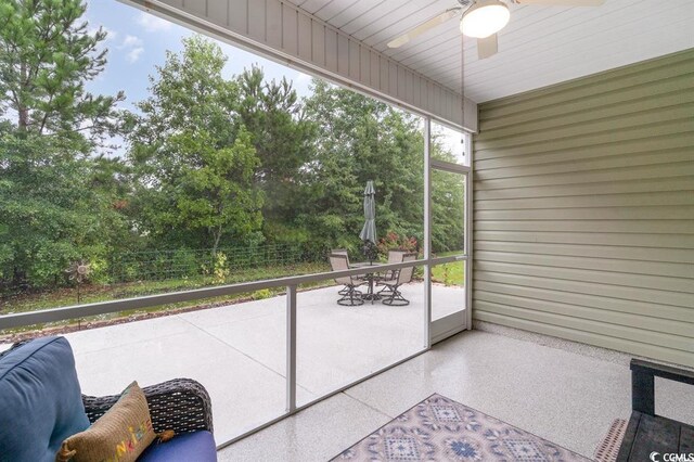 unfurnished sunroom featuring a ceiling fan