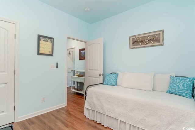 bedroom featuring wood finished floors and baseboards