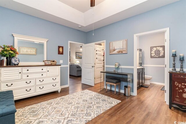 interior space with connected bathroom, baseboards, and wood finished floors