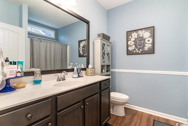 full bathroom featuring toilet, vanity, wood finished floors, a shower with curtain, and baseboards