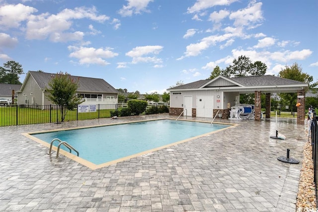 pool with a patio area and fence