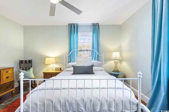 bedroom featuring ceiling fan, baseboards, and wood finished floors