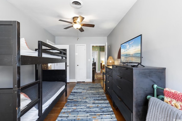 bedroom with visible vents, ceiling fan, baseboards, and dark wood-style flooring