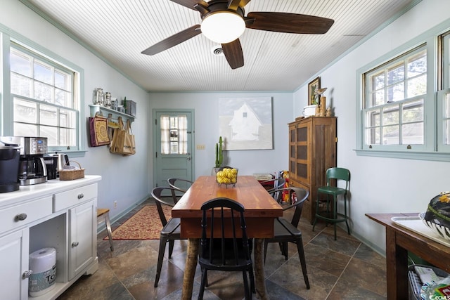 dining space featuring a ceiling fan and stone finish flooring