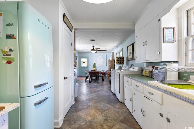 kitchen with a ceiling fan, freestanding refrigerator, light countertops, white cabinetry, and independent washer and dryer