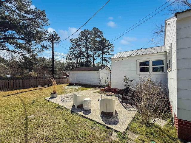 view of yard featuring a patio area, an outdoor structure, and fence