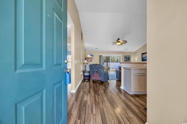 foyer entrance with ceiling fan, baseboards, and dark wood-style floors