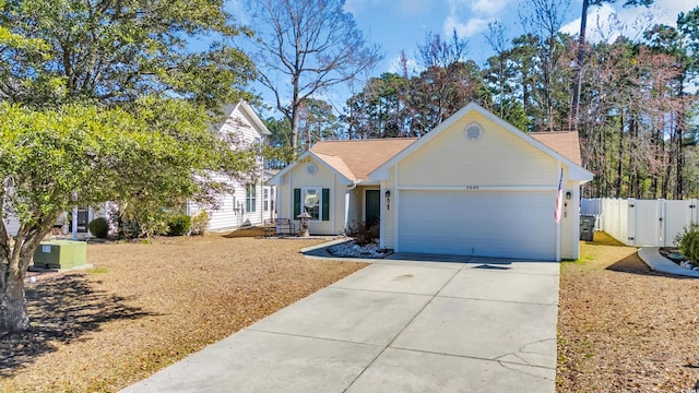 view of front of house featuring concrete driveway, fence, a garage, and a gate