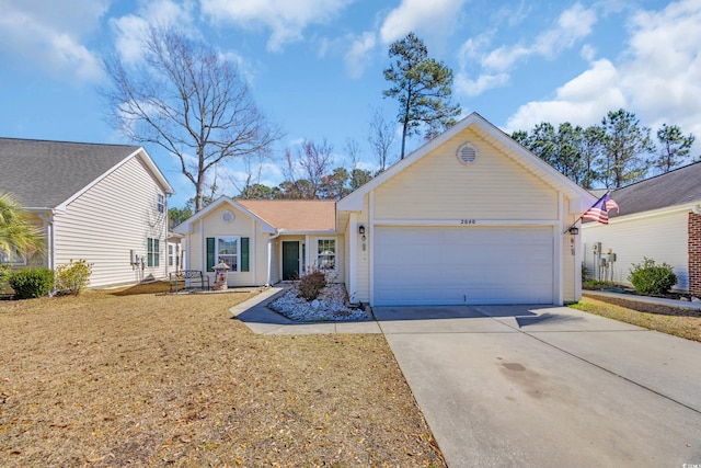 ranch-style home featuring driveway, an attached garage, and a front yard