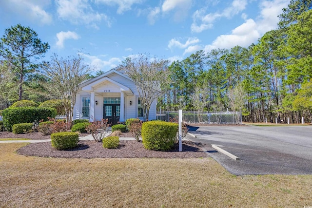 bungalow-style house with a front lawn and fence