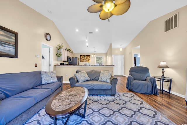 living area with visible vents, high vaulted ceiling, a ceiling fan, wood finished floors, and baseboards