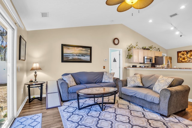 living room with vaulted ceiling, light wood-style flooring, baseboards, and visible vents