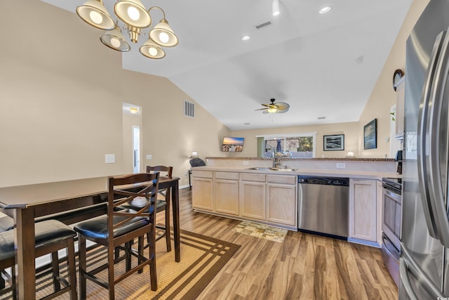 kitchen with visible vents, light wood-type flooring, a sink, stainless steel appliances, and lofted ceiling