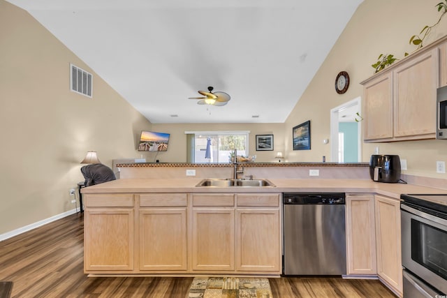 kitchen with visible vents, light brown cabinetry, appliances with stainless steel finishes, a peninsula, and a sink