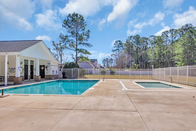 pool with a patio, a hot tub, and fence