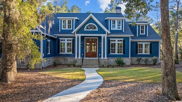 view of front facade featuring a shingled roof, a front yard, french doors, and a chimney