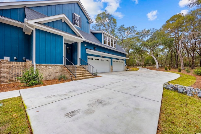 view of front of home featuring brick siding, a shingled roof, an attached garage, board and batten siding, and driveway