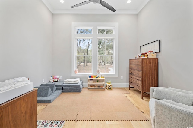 rec room with light wood finished floors, baseboards, ceiling fan, ornamental molding, and recessed lighting