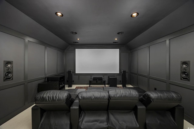 cinema room featuring lofted ceiling, a decorative wall, and recessed lighting