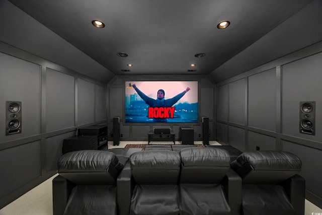 home theater room with lofted ceiling, a decorative wall, and recessed lighting