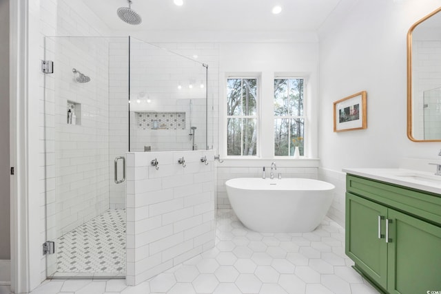 full bathroom with a freestanding tub, vanity, tile walls, a shower stall, and tile patterned floors