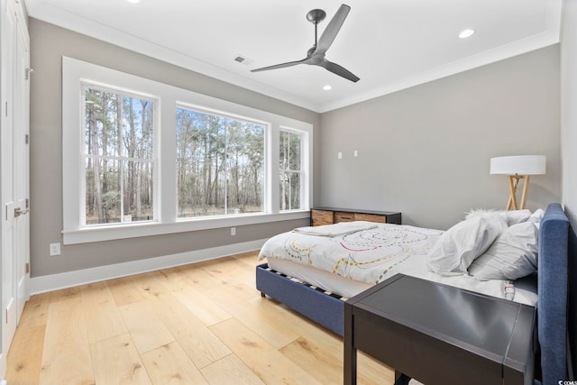 bedroom with light wood-type flooring, baseboards, multiple windows, and ornamental molding