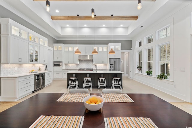 kitchen with appliances with stainless steel finishes, wine cooler, light countertops, and backsplash