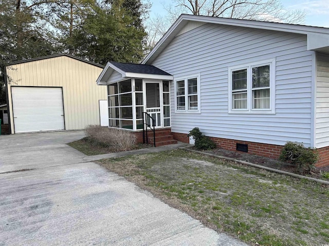 view of front facade with crawl space, driveway, a garage, and a sunroom