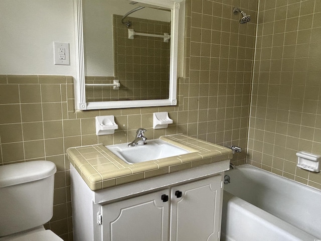 full bath featuring toilet, tile walls, and vanity