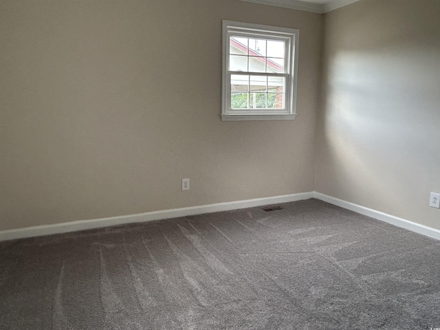 empty room featuring carpet and baseboards