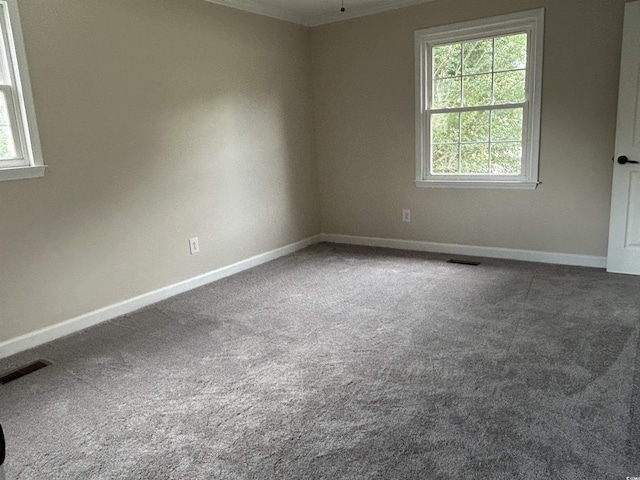 unfurnished room with carpet floors, visible vents, and baseboards