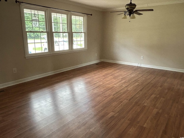 unfurnished room featuring dark wood-style floors, crown molding, baseboards, and ceiling fan