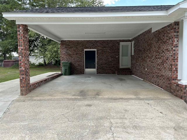 view of patio featuring entry steps, driveway, and an attached carport