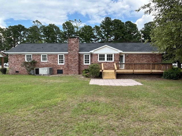 back of property featuring a chimney, crawl space, a deck, a yard, and brick siding