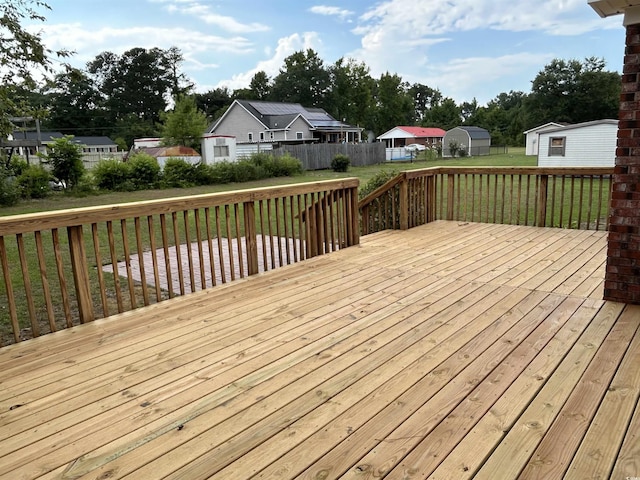 wooden terrace featuring a yard and fence