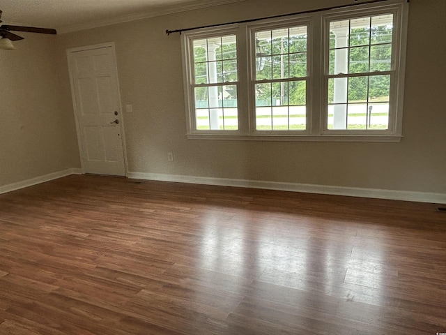 unfurnished room featuring baseboards, ceiling fan, wood finished floors, and crown molding