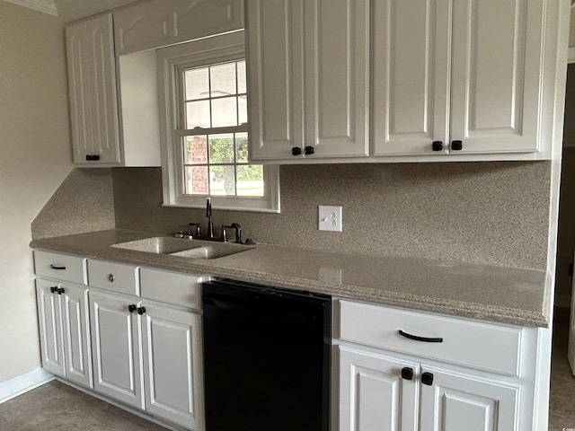 kitchen featuring black dishwasher, white cabinetry, decorative backsplash, and a sink