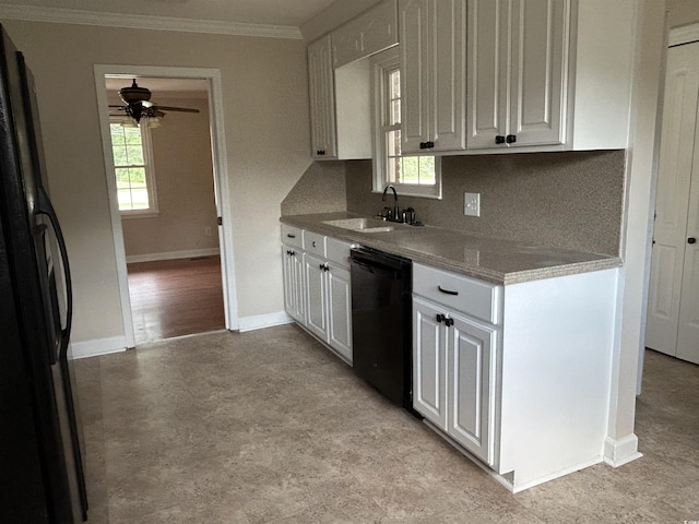 kitchen featuring a sink, baseboards, white cabinets, black appliances, and crown molding