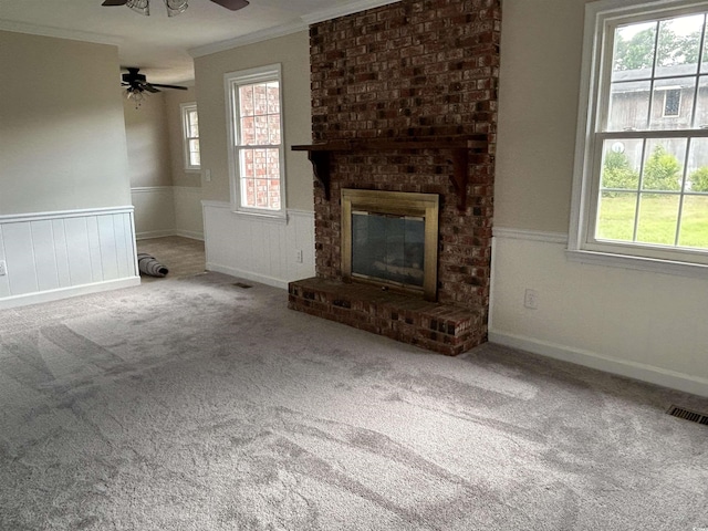 unfurnished living room featuring a wainscoted wall, carpet flooring, visible vents, and crown molding