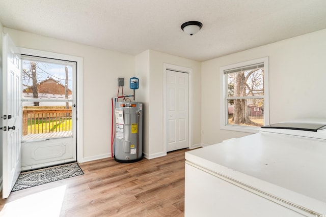 613 Calhoun Dr, Murrells Inlet, SC 29576 - laundry area featuring water heater, light wood-style flooring, healthy amount of natural light, and baseboards