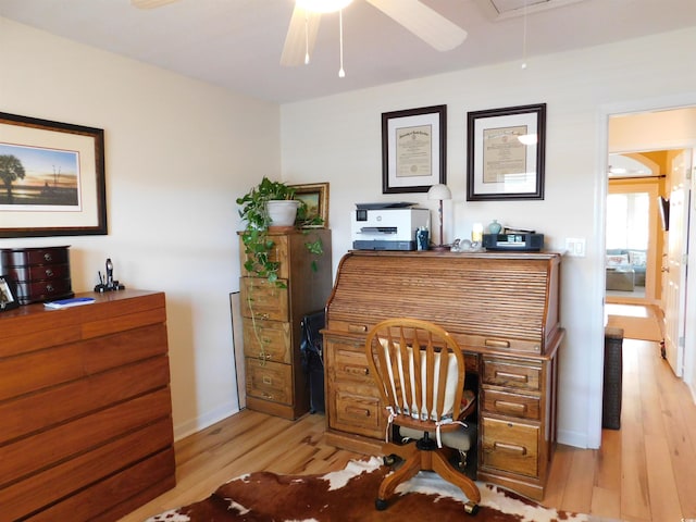 home office with baseboards, a ceiling fan, light wood-style flooring, and attic access