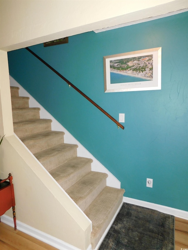 staircase featuring baseboards