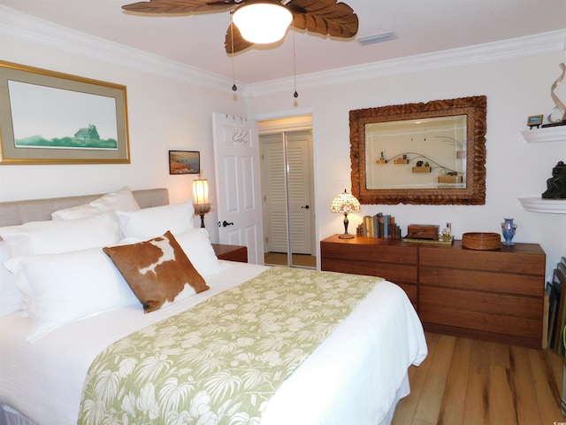 bedroom featuring visible vents, a ceiling fan, wood finished floors, crown molding, and a closet