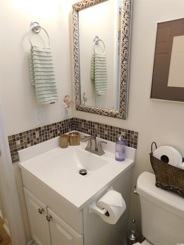 bathroom featuring tasteful backsplash, vanity, and toilet