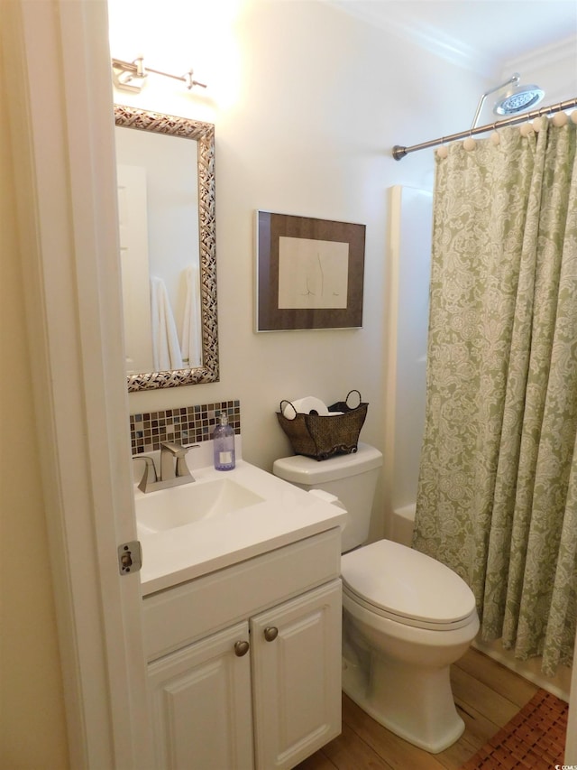 bathroom with toilet, shower / tub combo with curtain, wood finished floors, vanity, and backsplash